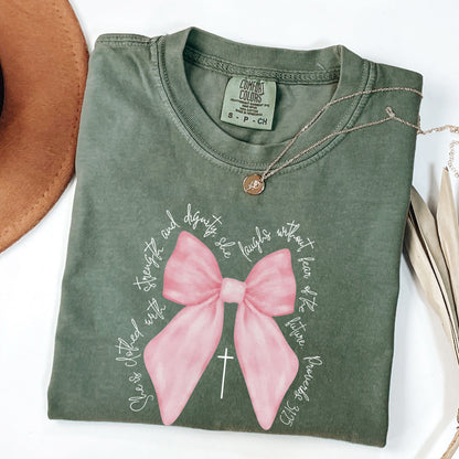 Christian Pink  Bow Bible Verse Faith Shirt, She is Clothed with Strength and Dignity Tee - Proverbs 31:25 Coquette Bow T-Shirt